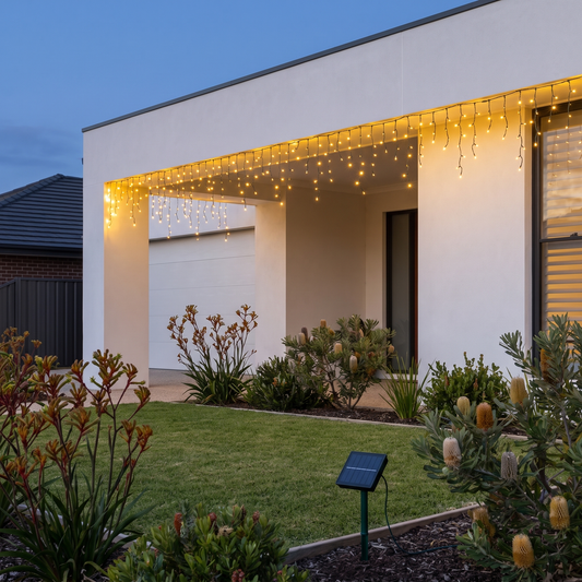 Warm White Solar LED Icicle Christmas Lights – 12.5m – glowing along a verandah at dusk