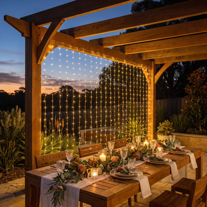 Warm White LED Curtain Christmas Lights – 6m x 3m, 600 LED – glowing over an alfresco pergola at dusk