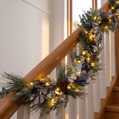 Blue Berry & Silver Pre-Lit Christmas Garland – 180cm, 35 LED – glowing on a timber staircase banister at dusk