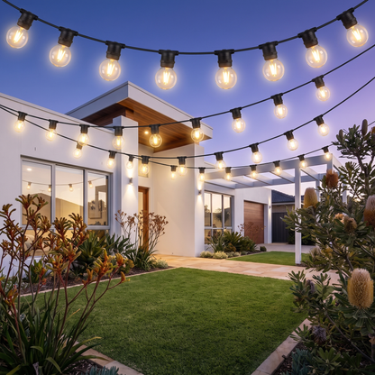 Warm White LED Festoon Christmas String Lights – 23m, 20 Bulbs – strung across the front yard of a modern home at dusk